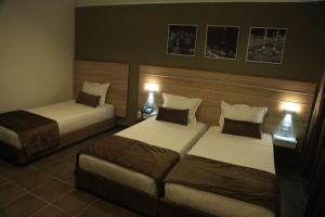 突尼斯MONDIAL HOTEL的酒店客房,设有两张床和一张沙发