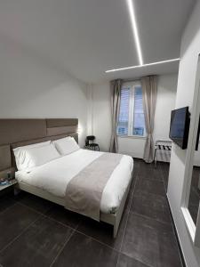 菲纳莱利古雷Joyfül Accomodation的卧室配有一张白色大床和电视。