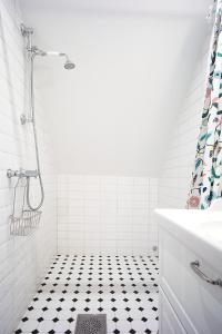 哥德堡Eklinds Rum och Trädgård的带淋浴的浴室以及黑白瓷砖地板。