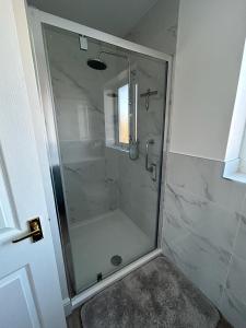 罗伊斯顿Magnolia House的浴室里设有玻璃门淋浴