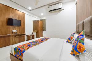 NarodaFabHotel Maan Palace的一间酒店客房,配有一张床和一台电视