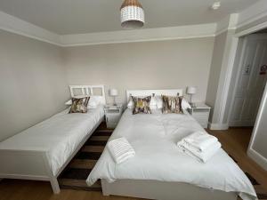 罗伊斯顿Magnolia House的一间卧室配有两张带白色床单和枕头的床。