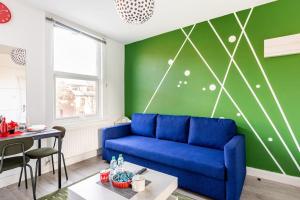 伦敦Parkside Stay North London - Victoria Line的客厅设有蓝色的沙发和绿色的墙壁