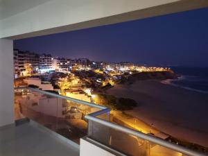 蓬塔赫尔莫萨Departamento en Punta Hermosa con Vista al Mar的以及享有海滩美景的夜间阳台。