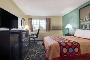 堪萨斯城速8KC / Adj. to世界乐园酒店的配有一张床和一台平面电视的酒店客房