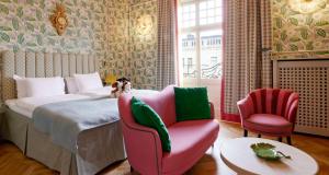 斯德哥尔摩Hotel Kung Carl, WorldHotels Crafted的一间卧室配有一张床、一把椅子和一张沙发