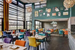 佩里纳特·莱斯·萨尔列夫吉尔格维贝斯特维斯特优质酒店的用餐室设有桌椅和窗户。