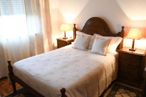 科尔武河畔米兰达Casa Raposo的一间卧室配有一张带两盏灯的床和一扇窗户。