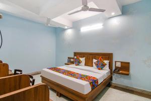 钱德加尔FabHotel Hari Residency的一间卧室配有一张床和吊扇