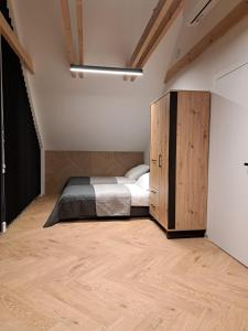 Złatnadomek blask Beskidu的一间卧室配有一张床和一个木制橱柜