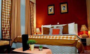 巴马科Villa Wilda的一间卧室设有一张带红色墙壁的大床