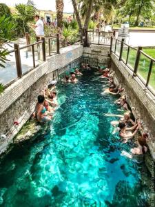 帕莫卡莱Pamukkale Sahin Boutique Hotel的一群人在游泳池游泳