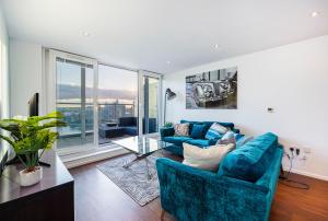 伦敦Austin David Apartments ExCeL的客厅配有蓝色的家具和大窗户
