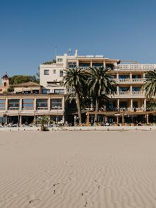 贝尼卡西姆沃拉马尔酒店的海滩上酒店前面有棕榈树