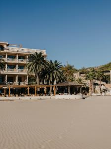 贝尼卡西姆沃拉马尔酒店的海滩上酒店,前方有棕榈树