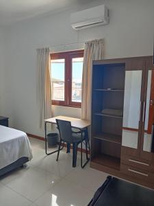 塔拉拉D'eluxe Hotel Talara的一间卧室配有书桌、床和窗户。
