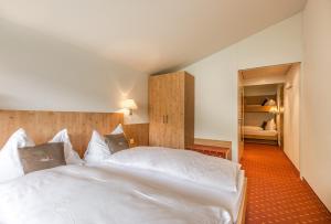 英格堡Hotel Bänklialp的一间带2张白色床的卧室和走廊