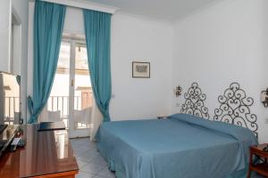 卡普里帕拉蒂姆马里酒店的一间卧室设有蓝色的床和一个阳台