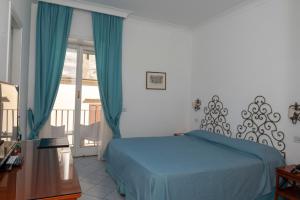 卡普里帕拉蒂姆马里酒店的一间卧室设有蓝色的床和一个阳台