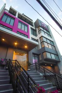 马尼拉OYO 1030 Ai Hotel的粉红色和白色的建筑,前面设有楼梯