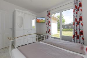 奥斯特巴德里克Haus Emilia Whg Baltic Dreams的一间卧室设有一张床和一个大窗户