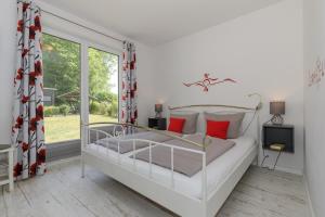奥斯特巴德里克Haus Emilia Whg Baltic Dreams的卧室配有带红色枕头的白色床