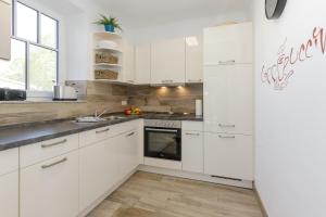 奥斯特巴德里克StrandEins Whg_ 6 _Baltica_的厨房配有白色橱柜和冰箱。