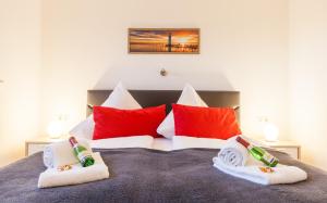 奥斯特巴德里克Ostseezauber的一间卧室配有红色和白色枕头的床