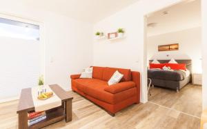 奥斯特巴德里克Ostseezauber的客厅配有橙色沙发和床。