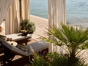 帕诺尔莫斯雷斯蒙The Royal Senses Resort & Spa Crete, Curio Collection by Hilton的阳台配有桌子和植物及水