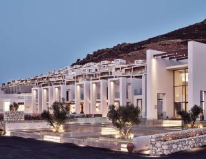 帕诺尔莫斯雷斯蒙The Royal Senses Resort & Spa Crete, Curio Collection by Hilton的一座白色的大建筑,后面有一座小山