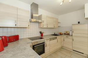 奥斯特巴德里克Villa Antonia Whg_ 4的厨房配有木制橱柜和炉灶烤箱。