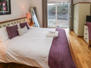 米尔福德港Curlew的一间卧室设有一张大床和大窗户
