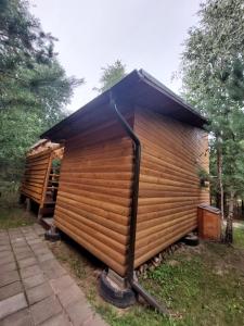 维尔纽斯Pasakų pirtelė的黑色屋顶的大型木制棚屋