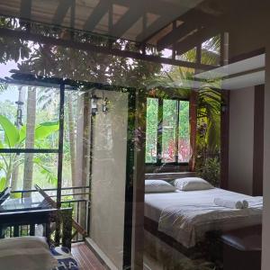 邦萨雷สวนผึ้ง2 รีสอร์ท - Suan Phueng 2 Resort的一间卧室设有一张床和一个大窗户