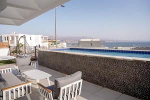 埃拉特YalaRent Mountainside Luxury apartments with Private Pool的一个带椅子的阳台和一个游泳池