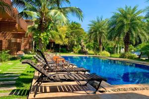 班帕那普兰Chill Villa的一组椅子坐在游泳池旁
