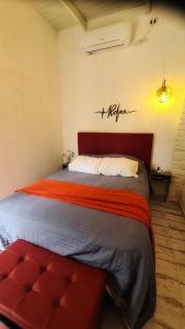 波萨达斯Casa confortable con pileta para 2 personas - Rincón Posadas的一间卧室配有一张大床和红色床头板