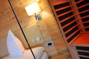 塞尔瓦迪加尔代纳山谷Chalet Elisabeth dolomites alpin & charme的一间带一盏灯和楼梯的床的房间