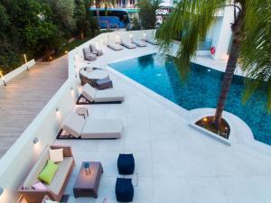 托隆Flisvos Royal的享有带躺椅和棕榈树的游泳池的顶部景致