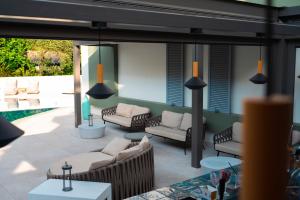 托隆Flisvos Royal的一个带沙发和椅子的庭院和一个游泳池