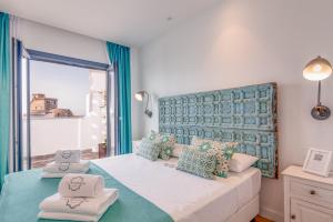 塔里法港口Spa酒店的一间卧室配有一张带蓝色和绿色枕头的大床