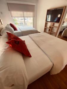 罗萨里奥里奥格兰德公寓式酒店的一间卧室配有两张床和一台平面电视