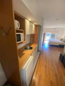 罗萨里奥里奥格兰德公寓式酒店的一个带水槽的小厨房和一间卧室