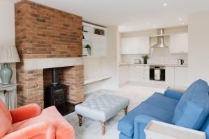 PrestonNightfold - 1 Bedroom Self-Catering Cottage的客厅设有砖砌壁炉和蓝色沙发。