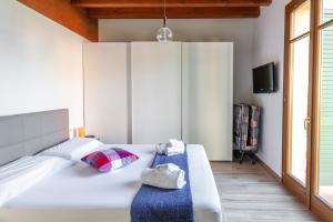 佩斯基耶拉德加达Lugana Resort & Sporting Club - Sermana Village的卧室配有一张白色大床和电视。
