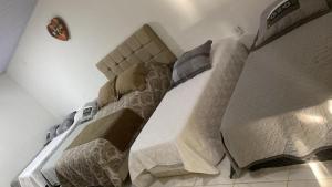 卡舒埃拉斯迪马卡库Hotel Fazenda Chiminelli的一间卧室配有两张床和被子。