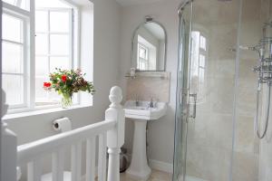 WhitchurchWatership Down Inn的浴室配有盥洗盆和带镜子的淋浴