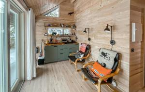 斯朱森Amazing Home In Sjusjen With Kitchen的一间小房子,配有两把椅子和厨房