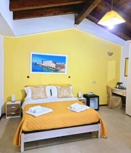 锡拉库扎特雷阿尔奇旅馆的一间卧室设有一张黄色墙壁的大床